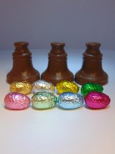 Drie klokken in melkchocolade omringd door eitjes