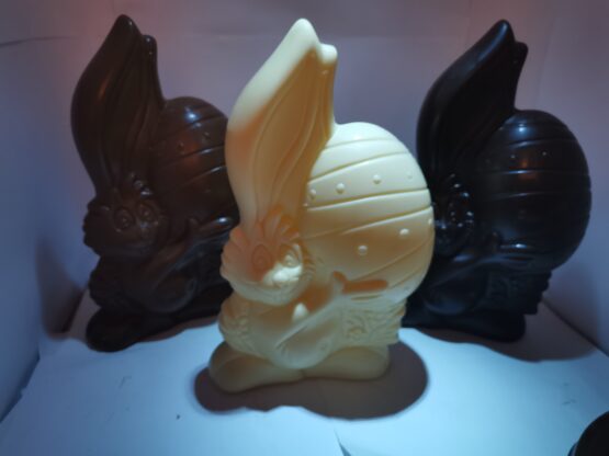 Happy met zijn handen rond het ei in witte chocolade