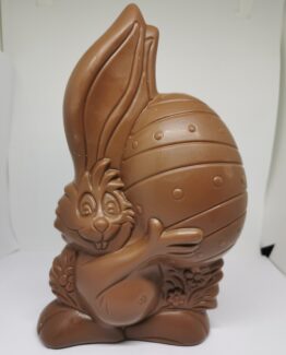 Happy met zijn handen rond het ei in melkchocolade